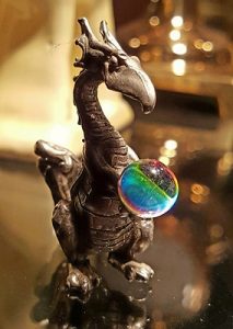 little figurine of a dragon with a crystal ball. 