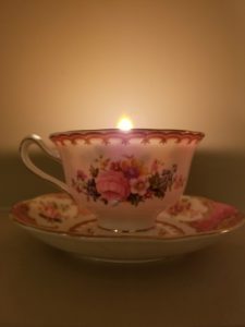Lit candle in a tea cup