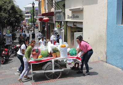 Street vendors pushing their cart of agua frescas