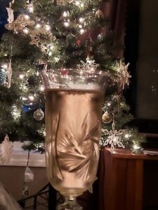 champagne in a crystal flute with a christmas tree in the background